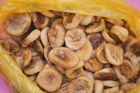 Dried figs in a yellow bag on a tableの写真素材