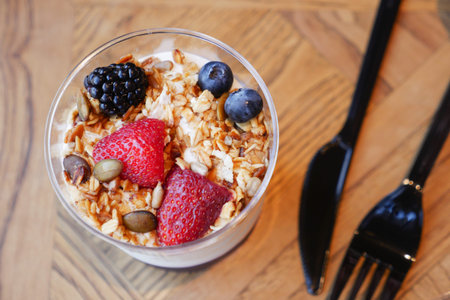 Healthy snack with yogurt and fruits on a wooden tableの写真素材