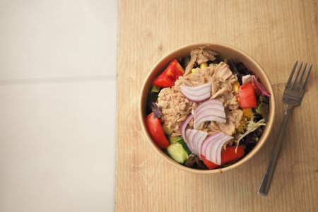 Tuna salad bowl with vegetables on wooden tableの写真素材