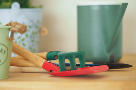 Gardening tools on a wooden table with a green watering canの写真素材