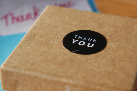 Gift box with thank you sticker on table