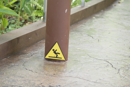 Warning sign near wet surface in a garden area