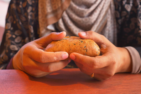 Holding a piece of bread in a warm setting