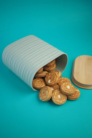 Cookies spill from a container on a bright surfaceの写真素材