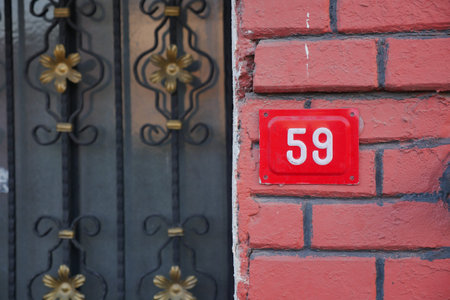 House number 59 near a black gate in a residential area