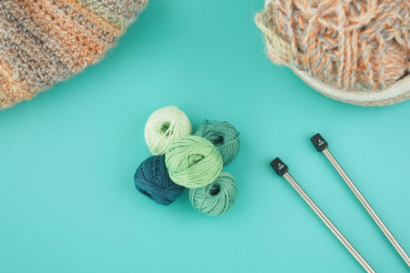 Knitting supplies on a blue table with yarn and needles