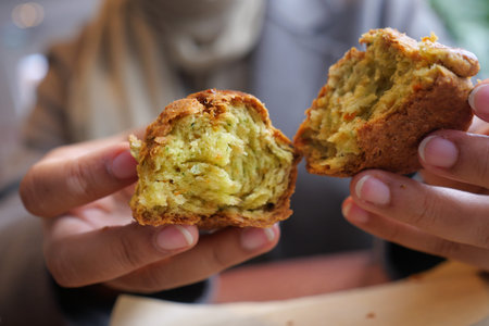 Warm bread roll is held in hands and broken apart