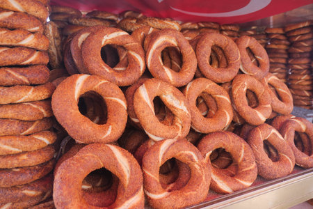 Turkish simits stacked neatly in a bakery stand ready for sale