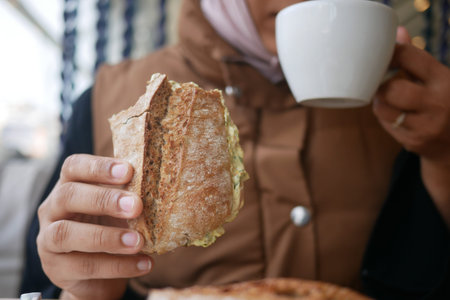 Enjoying bread and coffee at a quiet cafeの写真素材