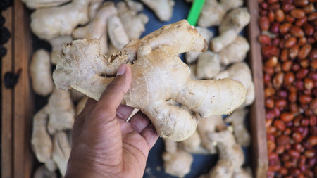 Holding fresh ginger root at a market in the morning