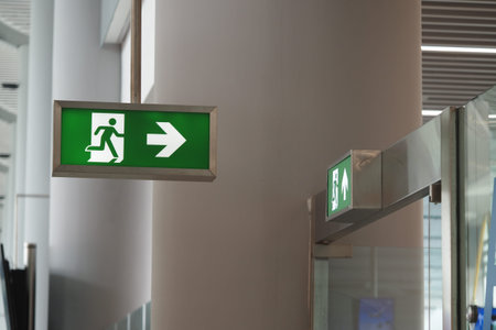 Sign directs passengers to exit area at airport terminalの写真素材