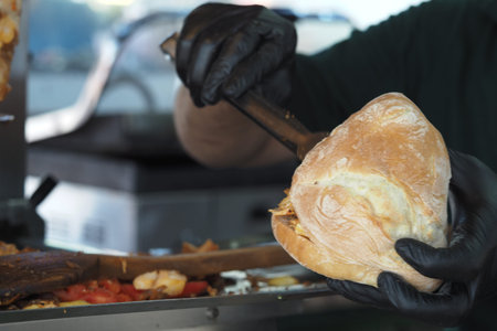 Food vendor prepares sandwich at local festival eventの写真素材