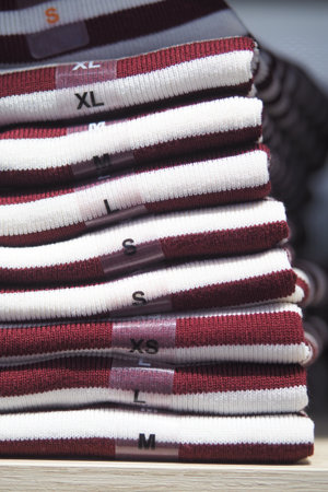 Shirts organized by size in a clothing store displayの写真素材