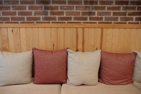 Cushions on a sofa against a brick wall in a casual spaceの写真素材