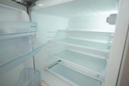 Empty refrigerator with clean shelves and no food insideの写真素材