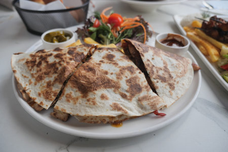 Gozleme or turkey pastry on a Plate with Salad, Sides, and Melted Cheeseの写真素材