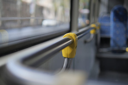 Yellow grip on bus handrail shows public transport use