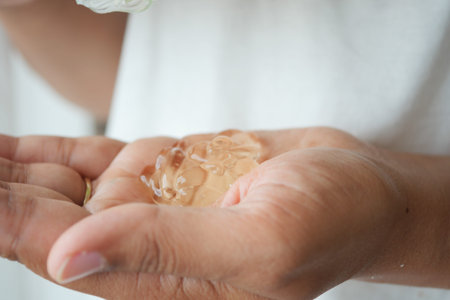 Hands hold aloe vera gel in indoor setting with soft lightingの写真素材