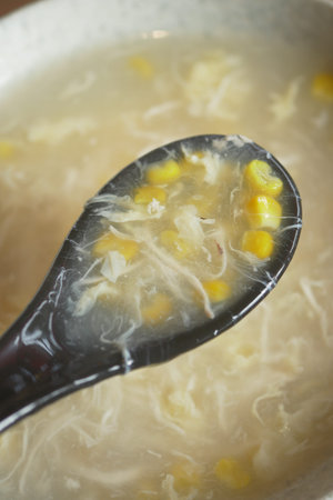 Corn soup served in a bowl with a spoon full of soupの写真素材