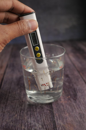 Testing water quality with a meter in a glassの写真素材