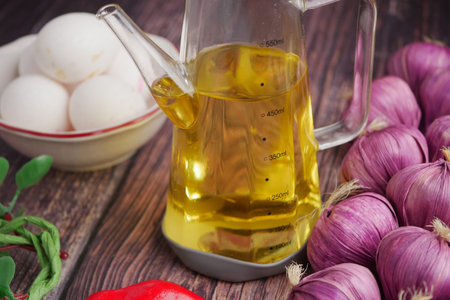 Cooking oil with eggs, onions, and pepper on the tableの写真素材
