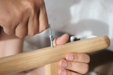 Hand tightening a screw into a bamboo pieceの写真素材
