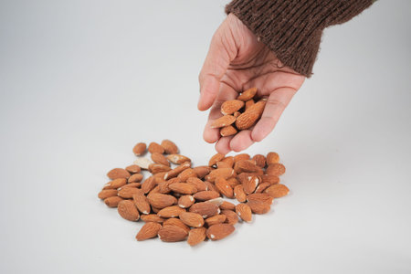 Gathering almonds in a hand on a light backgroundの写真素材