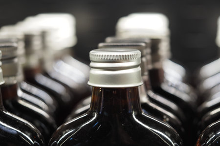 Collection of glass bottles on a store shelf in bright lightの写真素材