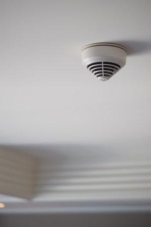 Smoke detector on ceiling in a quiet room during daytime