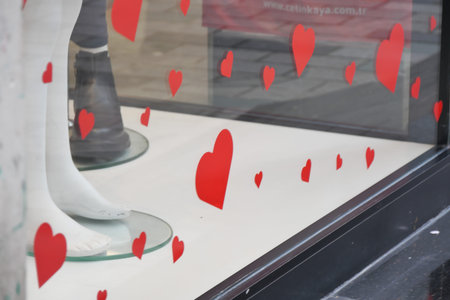 Red heart decorations in store window attract viewersの写真素材