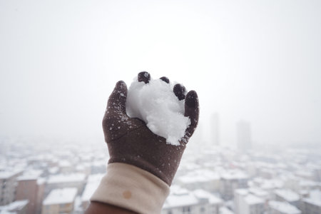 Snowball in hand during winter in city
