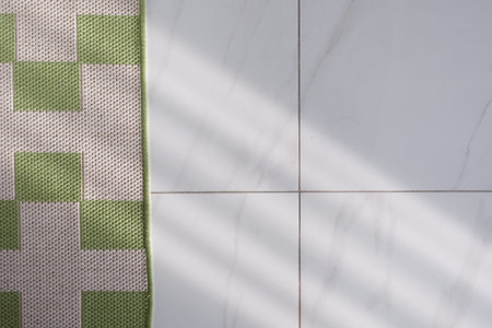 Green rug on white tile floor with shadows