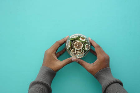 A person holds a bowl filled with dried lemon fruit .