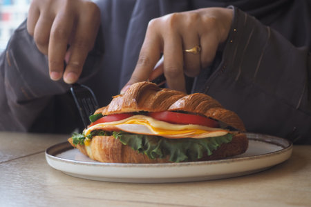 Enjoying a sandwich in a cafe during lunch hourの写真素材