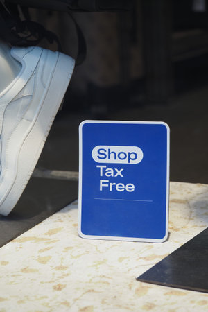 Shop sign showing tax free promotion near sneakersの写真素材
