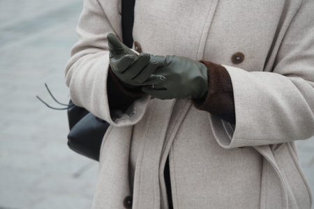 Hands adjusting gloves on a cold day in the cityの写真素材