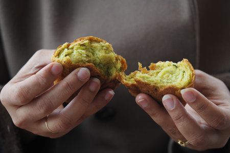 Person holds a baked green treat in handsの写真素材