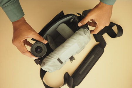 Taking out a camera lens from a bag at a workspace