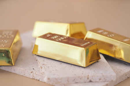 Gold bars on a stone surface with soft lighting