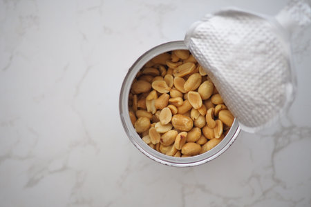 Peanuts in a can on a marble surface