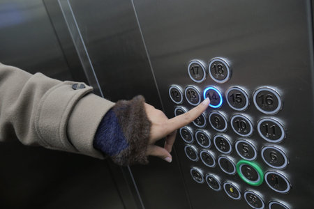 Person presses button for 14th floor