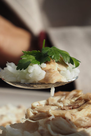 Eating chicken rice with coriander on a spoon