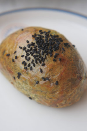 Bakery item with seeds on the top sitting on a plate