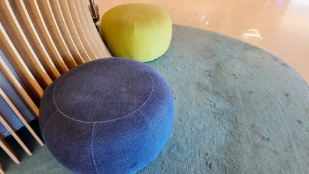 Colorful poufs on a carpet in a modern lobby space