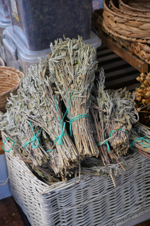 Bundles of dried herbs are stacked in a marketの写真素材