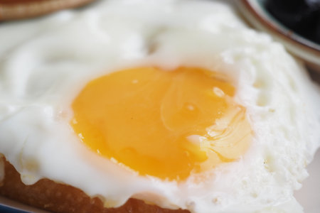 Egg yolk sits on a piece of bread for breakfast