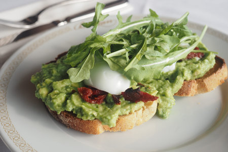 Enjoying toast with avocado and egg for breakfast