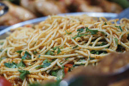 Noodles are served on a plate in a food market setting
