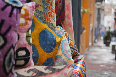 Colorful cushions are displayed on a street in a market