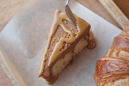 A slice of cheese cake with caramel topping is on a piece of paper